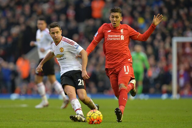 Manchester United's Spanish midfielder Ander Herrera (L) plays the ball under pressure from Liverpool's Brazilian midfielder Roberto Firmino (R) during the English Premier League football match between Liverpool and Manchester United at Anfield in Liverpool, northwest England, on January 17, 2016.  AFP PHOTO / PAUL ELLISRESTRICTED TO EDITORIAL USE. No use with unauthorized audio, video, data, fixture lists, club/league logos or 'live' services. Online in-match use limited to 75 images, no video emulation. No use in betting, games or single club/league/player publications. / AFP / PAUL ELLIS        (Photo credit should read PAUL ELLIS/AFP/Getty Images)