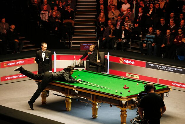 England's Ronnie O'Sullivan (2L) plays a shot during the Masters Snooker final against England's Barry Hawkins (C) at Alexandra Palace in north London on January 17, 2016.   AFP PHOTO / ADRIAN DENNIS / AFP / ADRIAN DENNIS        (Photo credit should read ADRIAN DENNIS/AFP/Getty Images)