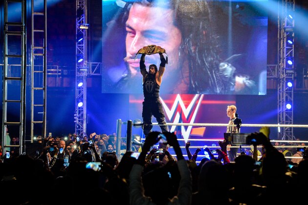 In this photograph taken on January 15, 2016, wrestler Roman Reigns holds up the Championship Belt during the World Wrestling Entertainment (WWE) Live India Tour in New Delhi.    Enthusiastic fans flocked to the event as WWE returned to the country after an interval of 13 years.   AFP PHOTO/ CHANDAN KHANNA / AFP / Chandan Khanna        (Photo credit should read CHANDAN KHANNA/AFP/Getty Images)