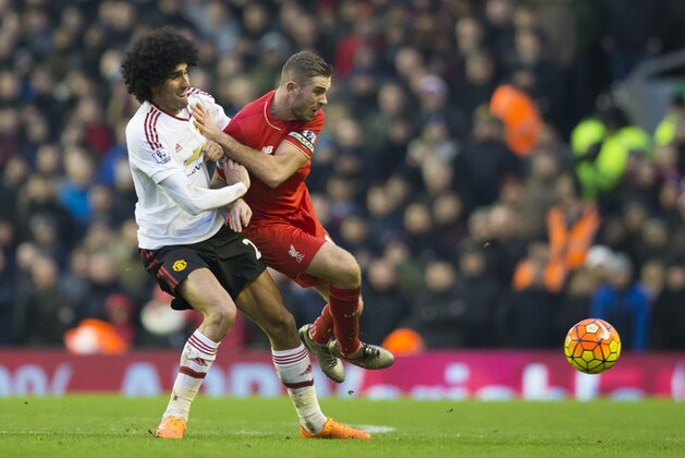 Manchester United's Marouane Fellaini, left, tackles Liverpool's Jordan Henderson, earning himself a yellow card, during the English Premier League soccer match between Liverpool and Manchester United at Anfield Stadium, Liverpool, England, Sunday, Jan. 17, 2016. (AP Photo/Jon Super)