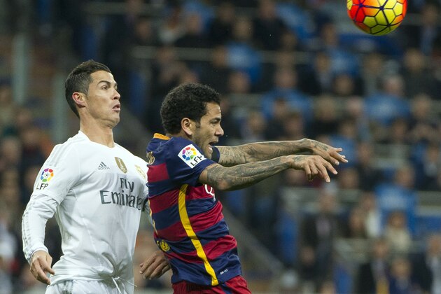 Barcelona's Brazilian defender Dani Alves (R) vies with Real Madrid's Portuguese forward Cristiano Ronaldo during the Spanish league 'Clasico' football match Real Madrid CF vs FC Barcelona at the Santiago Bernabeu stadium in Madrid on November 21, 2014.    AFP PHOTO / CURTO DE LA TORRE        (Photo credit should read CURTO DE LA TORRE/AFP/Getty Images)