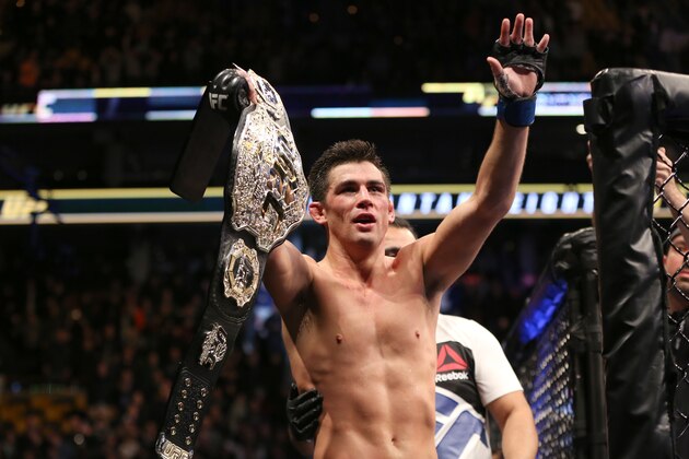 Dominick Cruz celebrates with the title belt after his win against TJ Dillashaw in a UFC bantamweight title match Sunday, Jan. 17, 2016, in Boston. Cruz regained the UFC bantamweight title Sunday night, outpointing Dillashaw by split decision. (AP Photo/Gregory Payan)