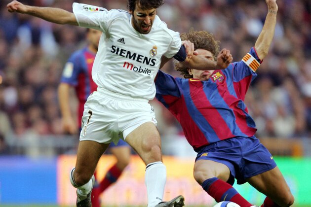 MADRID, SPAIN:  Real Madrid's Raul Gonzalez (L) vies with Barcelona's Carles Puyol (R) during their Spanish Premier League football match at Santiago Bernabeu stadium in Madrid. 10 April, 2005. AFP PHOTO/ Javier SORIANO.  (Photo credit should read JAVIER SORIANO/AFP/Getty Images)