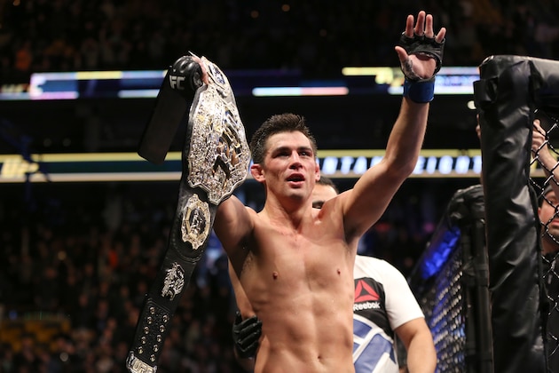 Dominick Cruz celebrates with the title belt after his win against TJ Dillashaw in a UFC bantamweight title match Sunday, Jan. 17, 2016, in Boston. Cruz regained the UFC bantamweight title Sunday night, outpointing Dillashaw by split decision. (AP Photo/Gregory Payan)
