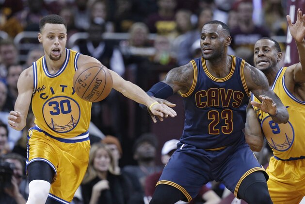 Golden State Warriors’ Stephen Curry (30) knocks the ball loose from Cleveland Cavaliers' LeBron James (23) in the first half of an NBA basketball game, Monday, Jan. 18, 2016, in Cleveland. Andre Iguodala (9) is at right. (AP Photo/Tony Dejak)