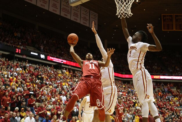 Jan 18, 2016; Ames, IA, USA; Oklahoma Sooners guard Isaiah Cousins (11) splits the defense of Iowa State Cyclones forward Abdel Nader (2) and forward Jameel McKay (1) at James H. Hilton Coliseum. Mandatory Credit: Reese Strickland-USA TODAY Sports