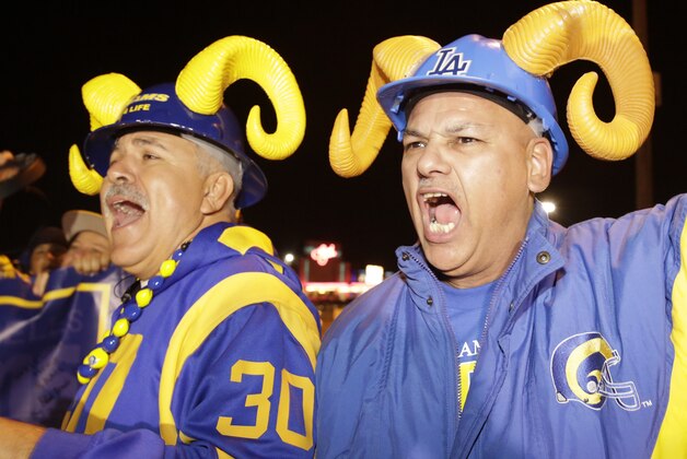 Football fans cheer for the return of the Rams to Los Angeles on the site of the old Hollywood Park horse-racing track in Inglewood, Calif., on Tuesday, Jan. 12, 2016. NFL owners voted Tuesday night to allow the St. Louis Rams to move to a new stadium at the site just outside Los Angeles, and the San Diego Chargers will have an option to share the facility. (AP Photo/Damian Dovarganes)