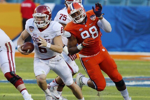 Oklahoma quarterback Baker Mayfield (6) carries the ball as Clemson defensive end Kevin Dodd (98) pursues, during the first half of the Orange Bowl NCAA college football semifinal playoff game, Thursday, Dec. 31, 2015, in Miami Gardens, Fla. (AP Photo/Joe Skipper)