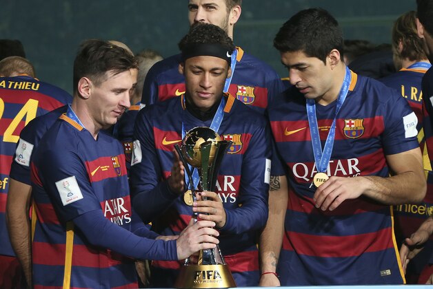 FC Barcelona team members, FC Barcelona’s Lionel Messi, left, FC Barcelona’s Neymar, center, and FC Barcelona’s Luis Suarez of Uruguay admire their trophy as they celebrate winning the final match against River Plate at the FIFA Club World Cup soccer tournament in Yokohama, near Tokyo, Sunday, Dec. 20, 2015. FC Barcelona beat River Plate 3-0. (AP Photo/Eugene Hoshiko)