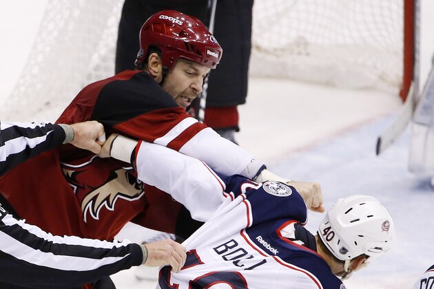 Arizona Coyotes' John Scott, left, punches Columbus Blue Jackets' Jared Boll (40) during a fight in the second period of an NHL hockey game Thursday, Dec. 17, 2015, in Glendale, Ariz. (AP Photo/Ross D. Franklin)