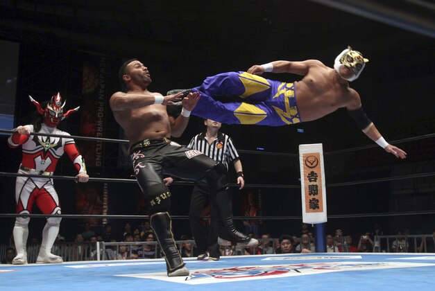 Tiger Mask from Japan, right, and Rocky Romero from Cuba compete in a NJPW (New Japan Pro-Wrestling) match in Taipei, Taiwan, Saturday, April 12, 2014. (AP Photo/Chiang Ying-ying)