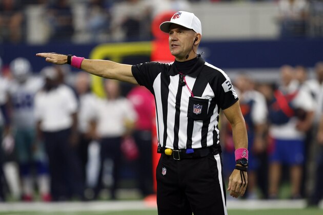 Referee Clete Blakeman (34) makes a call as he wears a ball cap with a pink accented attire in observance of Breast Cancer Awareness during an NFL football game between the New England Patriots and Dallas Cowboys, Sunday, Oct. 11, 2015, in Arlington, Texas. (AP Photo/Roger Steinman)