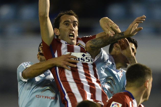Atletico Madrid's Uruguayan defender Diego Godin (2ndL) jumps for the ball during the Spanish league football match RC Celta de Vigo vs Club Atletico de Madrid at the Balaidos stadium in Vigo on January 10, 2016.   AFP PHOTO/ MIGUEL RIOPA / AFP / MIGUEL RIOPA        (Photo credit should read MIGUEL RIOPA/AFP/Getty Images)