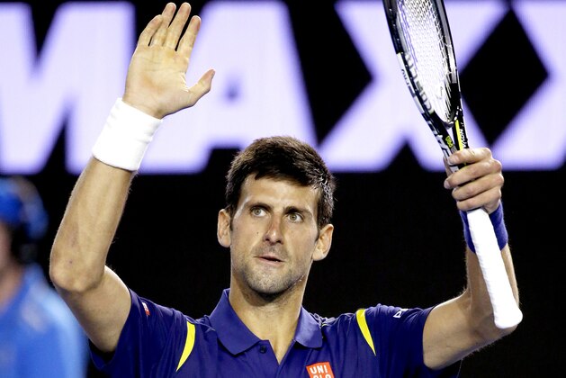 Novak Djokovic of Serbia raises his arms in celebration after defeating Quentin Halys of France in their second round match at the Australian Open tennis championships in Melbourne, Australia, Wednesday, Jan. 20, 2016.(AP Photo/Vincent Thian)
