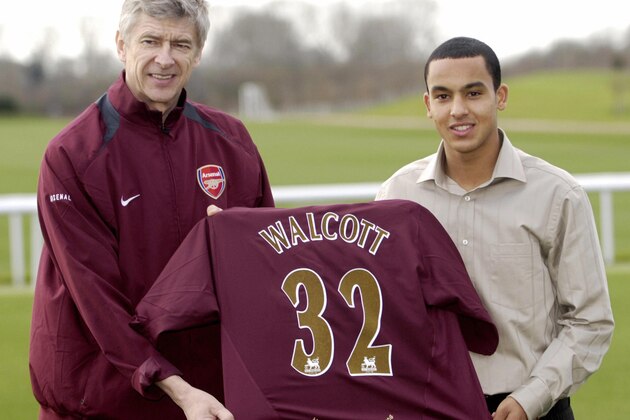 LONDON, United Kingdom:  16 year-old Theo Walcott (R) poses with Arsenal football club manager Arsene Wenger and his new team shirt at the Club's training ground near London Colney in Hertfordshire, 20 January 2006.  Walcott, the hottest young prospect in English football, has opted to sign for Arsenal in a deal that could eventually cost the Gunners GBP12 m (approx. 17.5m euros)  Walcott is so young that he will not even be able to sign a professional contract for his new club until he turns 17 on March 16. AFP PHOTO/ANDREW STUART  (Photo credit should read ANDREW STUART/AFP/Getty Images)