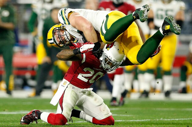 GLENDALE, AZ - JANUARY 16: Fullback John Kuhn #30 of the Green Bay Packers is hit by strong safety Deone Bucannon #20 of the Arizona Cardinals during the second half of the NFC Divisional Playoff Game at University of Phoenix Stadium on January 16, 2016 in Glendale, Arizona.  (Photo by Christian Petersen/Getty Images)