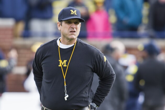 Michigan head coach Jim Harbaugh walks the Michigan Stadium field before an NCAA college football game against Ohio State in Ann Arbor, Mich., Saturday, Nov. 28, 2015. (AP Photo/Tony Ding)