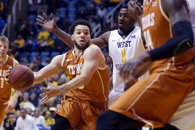 Texas guard Javan Felix (3) drives past West Virginia forward Jonathan Holton (1) during the first half of an NCAA college basketball game, Wednesday, Jan, 20, 2016, in Morgantown, W.Va. (AP Photo/Raymond Thompson)