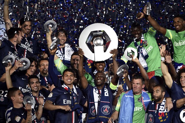 Paris Saint-Germain's French defender Zoumana Camara (C)holds is trophy on the podium after winning the French L1 title at the end of the French L1 football match Paris Saint-Germain (PSG) vs Reims on May 23, 2015 at the Parc des Princes stadium in Paris.  AFP PHOTO / FRANCK FIFE        (Photo credit should read FRANCK FIFE/AFP/Getty Images)