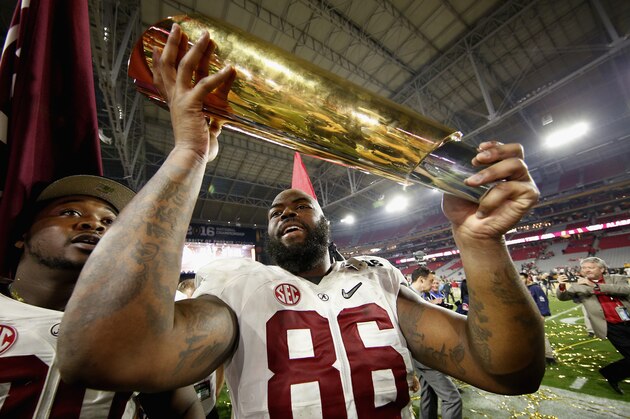 GLENDALE, AZ - JANUARY 11:  A'Shawn Robinson #86 of the Alabama Crimson Tide celebrates by hoisting the College Football Playoff National Championship Trophy after defeating the Clemson Tigers in the 2016 College Football Playoff National Championship Game at University of Phoenix Stadium on January 11, 2016 in Glendale, Arizona.  The Crimson Tide defeated the Tigers with a score of 45 to 40.  (Photo by Christian Petersen/Getty Images)