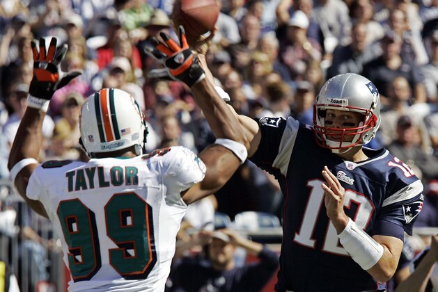 New England Patriots quarterback Tom Brady, right, throws under pressure from Miami Dolphins Jason Taylor (99) during the first  quarter in Foxborough,Mass., Sunday, Oct., 8, 2006. New England won, 20-10.  (AP Photo/Chitose Suzuki)