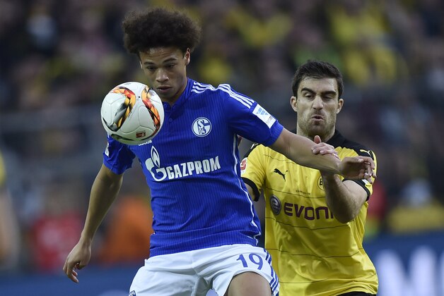 Schalke's Leroy Sane, left, and Dortmund's Sokratis challenge for the ball during the German Bundesliga soccer match between Borussia Dortmund and FC Schalke 04 in Dortmund, Germany, Sunday, Nov. 8, 2015. (AP Photo/Martin Meissner)