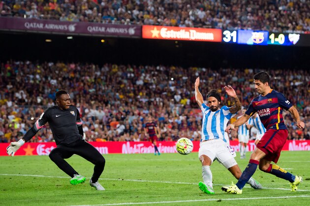 BARCELONA, SPAIN - AUGUST 29:  Luis Suarez (R) of FC Barcelona kicks the ball next to Marcos Angeleri (C) and Carlos Kameni of Malaga CF during the La Liga match between FC Barcelona and Malaga CF at Camp Nou on August 29, 2015 in Barcelona, Spain.  (Photo by Alex Caparros/Getty Images)