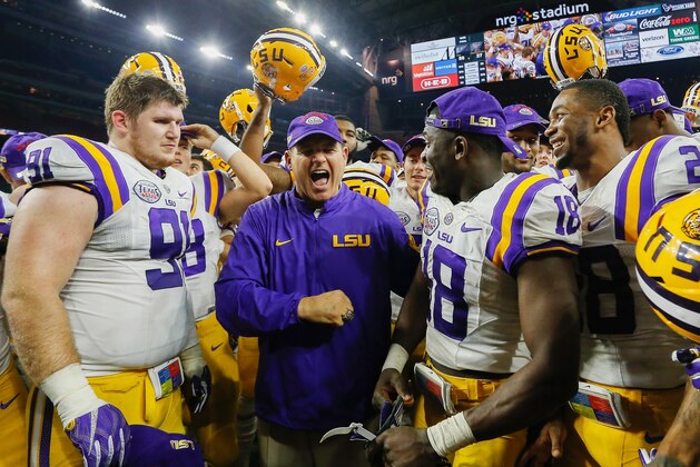 LSU head coach Les Miles, center, celebrates with defensive tackle Christian LaCouture (91) and cornerback Tre'Davious White (18)  after defeating Texas Tech in the Texas Bowl NCAA football game Wednesday, Dec. 30, 2015, in Houston. LSU won 56-27. (AP Photo/Bob Levey)