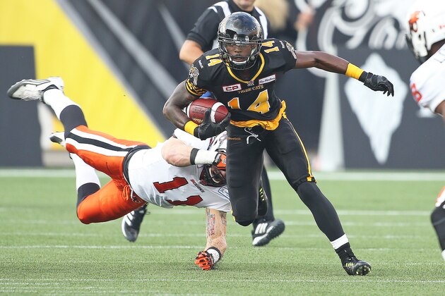 HAMILTON, ON - AUGUST 15:  Terrell Sinkfield Jr. #14 of the Hamilton Tiger-Cats eludes a tackle against the BC Lions during a CFL football game at Tim Hortons Field on August 15, 2015 in Hamilton, Ontario, Canada. The Tiger-Cats defeated the Lions. (Photo by Claus Andersen/Getty Images)