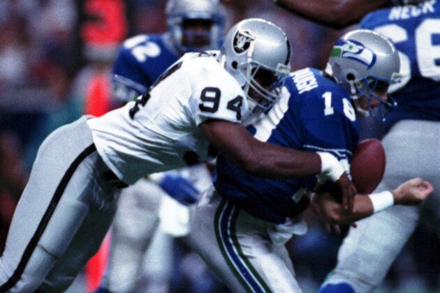 FILE - In this Oct. 18, 1992, file photo, Los Angeles Raiders' Anthony Smith (94) sacks Seattle Seahawks quarterback Stan Gelbaugh during the second quarter of an NFL football game in Seattle. Smith, a former defensive end with the Oakland and Los Angeles Raiders, has been found guilty Thursday, Nov. 5, 2015,  in the shooting deaths of two brothers in 1999 and the stabbing death of another man in 2001. Prosecutors say all three had been kidnapped and tortured. His attorney, Michael Evans, says he'll appeal the convictions.  (AP Photo/Gary Stewart)