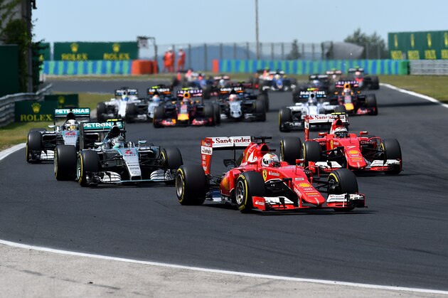 BUDAPEST, HUNGARY - JULY 26:  Sebastian Vettel of Germany and Ferrari leads Nico Rosberg of Germany and Mercedes GP, Lewis Hamilton of Great Britain and Mercedes GP and Kimi Raikkonen of Finland and Ferrari into the second corner during the Formula One Grand Prix of Hungary at Hungaroring on July 26, 2015 in Budapest, Hungary.  (Photo by Lars Baron/Getty Images)