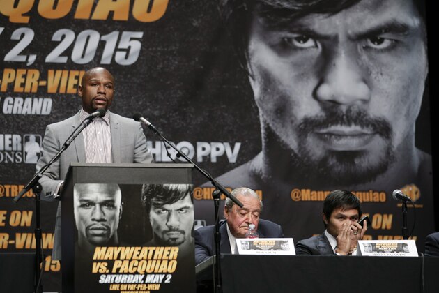 Floyd Mayweather Jr., left, speaks as Manny Pacquiao, right, of the Philippines, speaks into his phone while sitting next to promoter Bob Arum during a news conference, Wednesday, March 11, 2015, in Los Angeles. Mayweather and Pacquiao are scheduled to fight in Las Vegas on May 2. (AP Photo/Jae C. Hong)