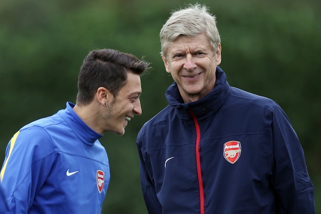 Arsenal's German midfielder Mesut Ozil (L) and Arsenal's French manager Arsene Wenger speak during a training session at the club's complex in London Colney, on September 17, 2013. Arsenal travel to play Olympique Marseille in a UEFA Champions League match Wednesday. AFP PHOTO / ADRIAN DENNIS        (Photo credit should read ADRIAN DENNIS/AFP/Getty Images)