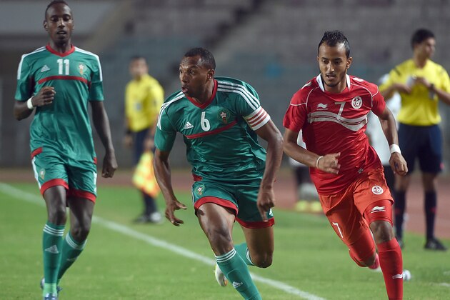 Morocco's forward Brahim Nakach (C) vies for the ball with Tunisian forward Hamza Lahmar (R) during an African Nations Championship (CHAN) qualifying match on October 25, 2015 in Rades. Both Tunisia and Morocco have already quallified for the 16-nation tournament, which Rwanda host in January and February. AFP PHOTO / FETHI BELAID        (Photo credit should read FETHI BELAID/AFP/Getty Images)
