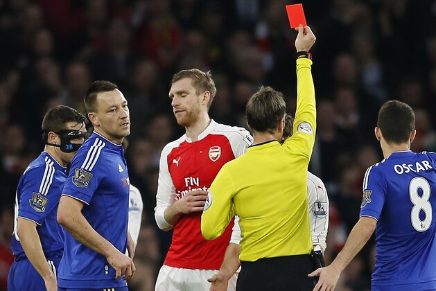 Arsenal's Per Mertesacker, centre, is shown a red card  and sent off by referee Mark Clattenburg for a foul on Chelsea's Diego Costa during the English Premier League soccer match between Arsenal and Chelsea at the Emirates stadium in London, Sunday, Jan. 24, 2016.(AP Photo/Frank Augstein)