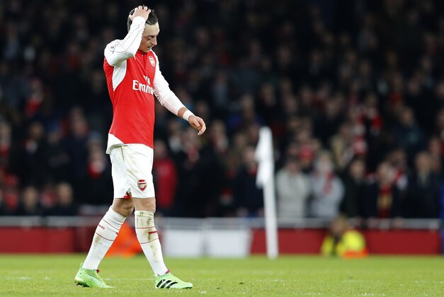 Arsenal's Mesut Ozil puts his hand to his head as he waits for a free kick to be taken during the English Premier League soccer match between Arsenal and Chelsea at the Emirates stadium in London, Sunday, Jan. 24, 2016.(AP Photo/Frank Augstein)