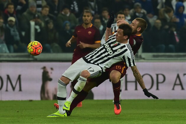 Roma's midfielder from Italy Daniele De Rossi (back) fights for the ball with Juventus' forward from Croatia Mario Mandzukic during the Italian Serie A football match Juventus vs AS Roma at 'Juventus Stadium' in Turin on January 24, 2016. AFP PHOTO / GIUSEPPE CACACE / AFP / GIUSEPPE CACACE        (Photo credit should read GIUSEPPE CACACE/AFP/Getty Images)