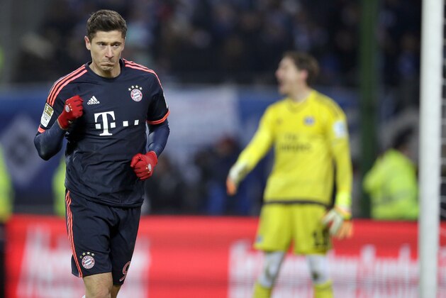 Bayern's Robert Lewandowski, left, celebrates after scoring the opening goal by a penalty during the German Bundesliga soccer match between Hamburger SV and FC Bayern Munich in Hamburg, Germany, Friday, Jan. 22, 2016. At right is Hamburg's goalkeeper Rene Adler. (AP Photo/Michael Sohn)