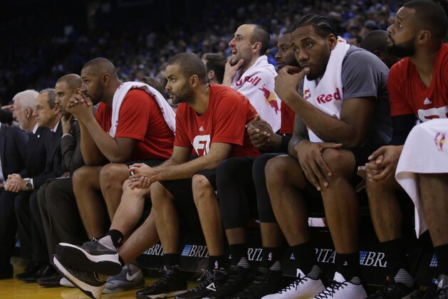 Members of the San Antonio Spurs watch from the bench in the closing minutes of a 120-90 loss to the Golden State Warriors during an NBA basketball game Monday, Jan. 25, 2016, in Oakland, Calif. (AP Photo/Marcio Jose Sanchez)