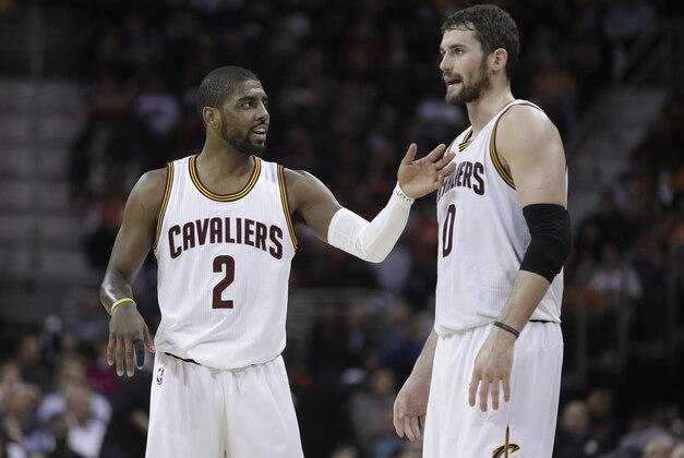 Cleveland Cavaliers' Kyrie Irving, left, talks with Kevin Love during an NBA basketball game against the Miami Heat Wednesday, Feb. 11, 2015, in Cleveland. (AP Photo/Tony Dejak)