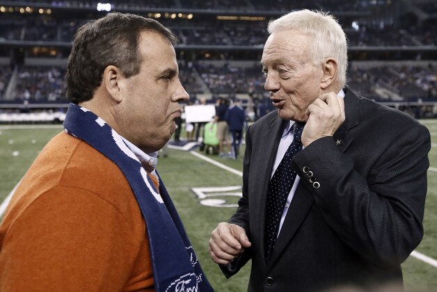 FILE - New Jersey Gov. Chris Christie, left, talks with Dallas Cowboys team owner Jerry Jones, right, on the field as the teams warm up before an NFL football game against the Indianapolis Colts, in this, Dec. 21, 2014 file photo taken in Arlington, Texas. Christie's fanboy devotion to the Cowboys drew more scrutiny after he was captured on camera — bedecked in the lucky sweater — jumping up and down and hugging Cowboys owner Jerry Jones after Dallas defeated the Detroit Lions 24-20 in last week's wild-card game Sunday Jan. 4, 2015. (AP Photo/Brandon Wade, File)
