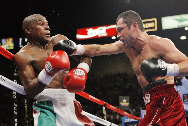 Oscar De La Hoya, right, lands a right on Floyd Mayweather Jr. during the sixth round of their WBC super welterweight world championship boxing match on Saturday, May 5, 2007, at the MGM Grand Garden Arena  in Las Vegas. (AP Photo/Jae C. Hong)