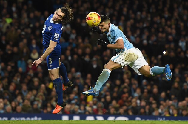 Manchester City's Argentinian striker Sergio Aguero (R) beats Everton's English defender Leighton Baines to head the ball towards goal during the English League Cup semi-final second leg football match between Manchester City and Everton the Etihad Stadium in Manchester, north west England, on January 27, 2016. / AFP / Paul Ellis / RESTRICTED TO EDITORIAL USE. No use with unauthorized audio, video, data, fixture lists, club/league logos or 'live' services. Online in-match use limited to 75 images, no video emulation. No use in betting, games or single club/league/player publications.  /         (Photo credit should read PAUL ELLIS/AFP/Getty Images)