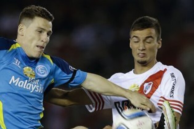 Kevin Gameiro of Spain's Sevilla, left, fights for the ball with Emanuel Mammana of Argentina's River Plate, during the Supercopa Euroamericana friendly soccer match in Buenos Aires, Argentina, Thursday, March 26, 2015. (AP Photo/Natacha Pisarenko)