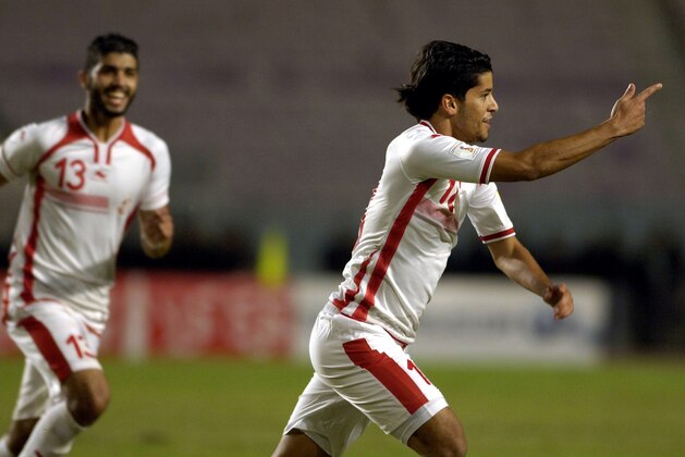 Tunisian striker Saad Bguir  (R) celebrates with his teammate Ferjani Sassi after scoring a goal during the FIFA World Cup 2018 qualifying football match between Tunisia and Mauritania at Rades Olympic Stadium near Tunis on November 17, 2015. AFP PHOTO / FETHI BELAID        (Photo credit should read FETHI BELAID/AFP/Getty Images)