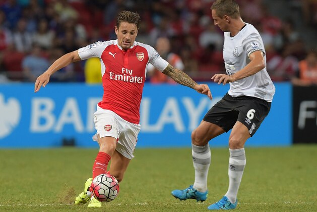 Arsenal's Mathieu Debuchy, left, controls the ball past Everton's Phil Jagielka during the soccer match in the Asia Trophy in Singapore, Saturday July 18, 2015. (AP Photo/Joseph Nair)