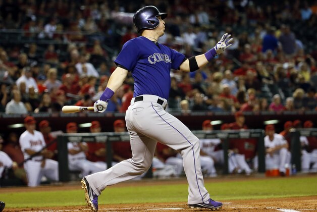 Colorado Rockies left fielder Corey Dickerson hits against the Arizona Diamondbacks during the first inning of a baseball game, Tuesday, Sept. 29, 2015, in Phoenix. (AP Photo/Matt York)