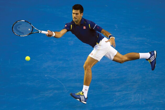 Novak Djokovic of Serbia plays a backhand return to Roger Federer of Switzerland during their semifinal match at the Australian Open tennis championships in Melbourne, Australia, Thursday, Jan. 28, 2016.(AP Photo/Vincent Thian)