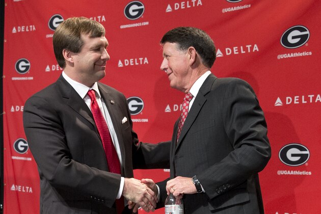 Alabama defensive coordinator Kirby Smart, left, speaks to Georgia athletic director Greg Mcgarity after during a press conference where he was introduced as Georgia's new head football coach  Monday, Dec. 7, 2015, in Athens, Ga. Smart will stay with the Crimson Tide through the NCAA college playoffs. (AP Photo/John Bazemore)