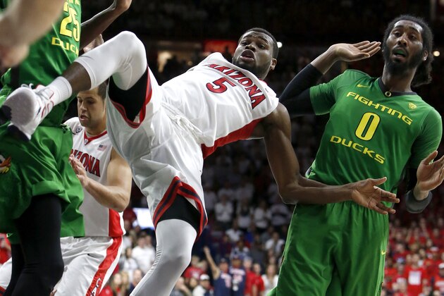 Arizona guard Kadeem Allen (5) gets fouled by Oregon forward Dwayne Benjamin (0) during the second half of an NCAA college basketball game, Thursday, Jan. 28, 2016, in Tucson, Ariz. Oregon defeated Arizona 83-75. (AP Photo/Rick Scuteri)
